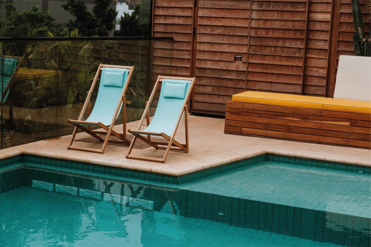 The Click Clack Hotel Медельин Экстерьер фото A pair of deck chairs by a pool